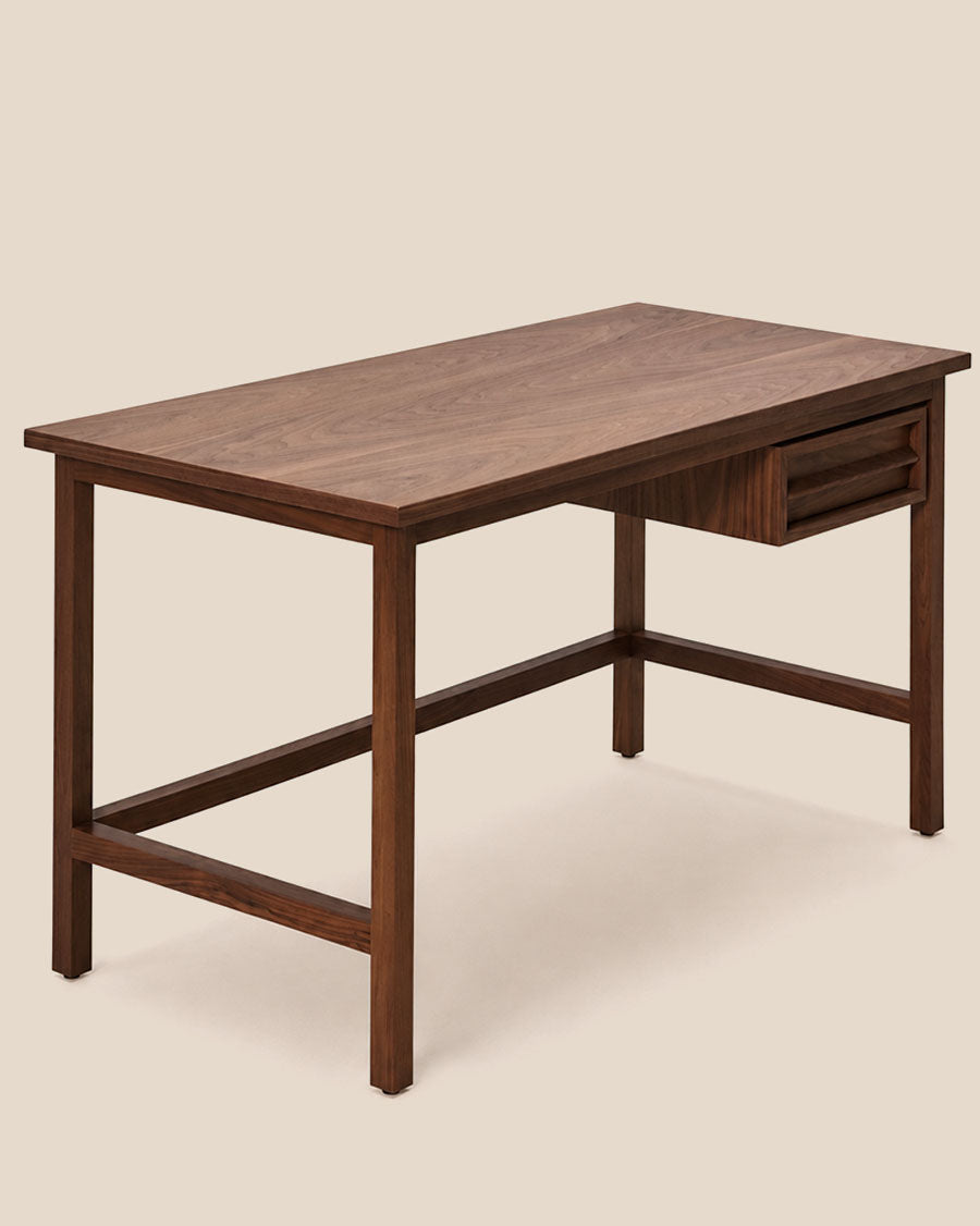 Gros plan d'un bureau en bois avec un seul tiroir, présenté dans un décor intérieur épuré.
